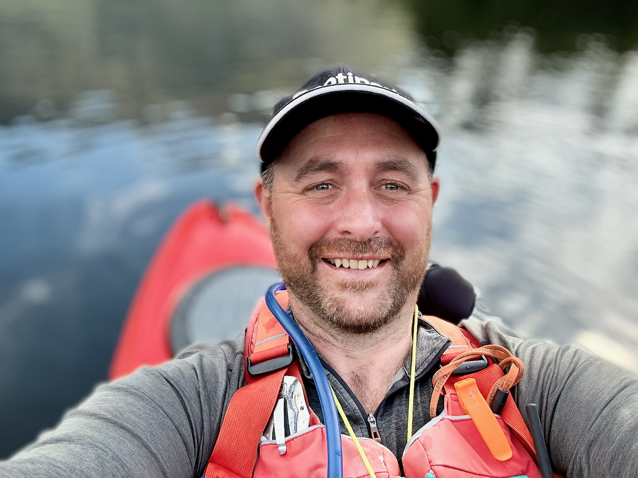 Selfie of me in my red Dagger Katana kayak afloat on a lake wearing Palm Peyto buoyancy aid.